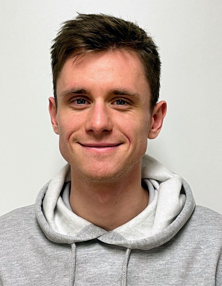 Portret van Lars De Donder, glimlachend, in een grijze hoodie
